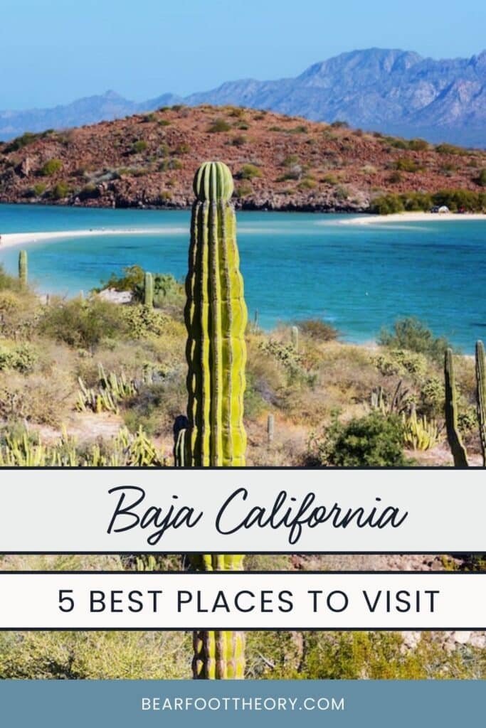 A pinnable image of a blue bay with desert mountains in the background and a cactus in the foreground with cars on the beach. The images has the words "Baja California - 5 best places to visit"